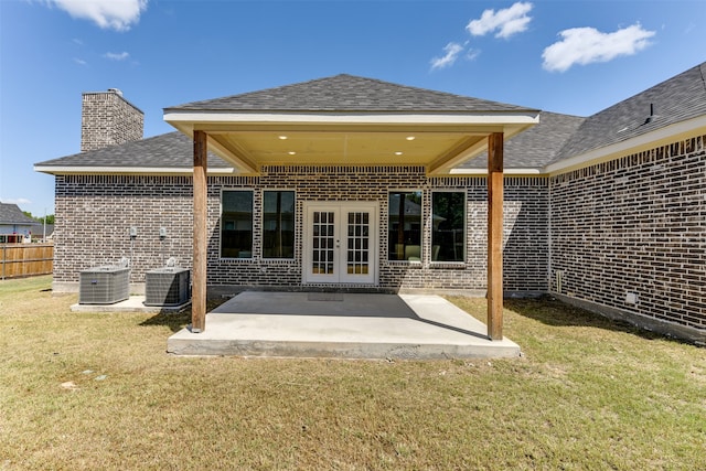 back of property with central AC, a patio area, and a yard