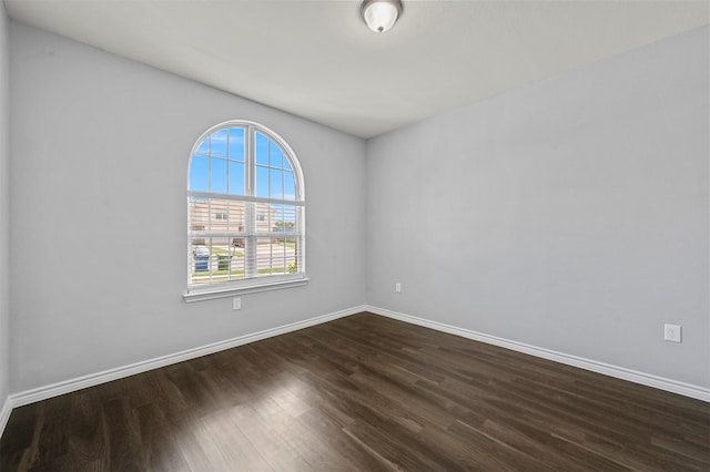 empty room with plenty of natural light and dark wood-type flooring