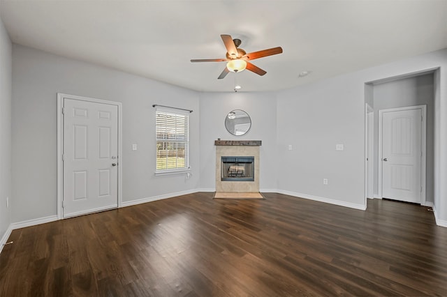 unfurnished living room featuring a premium fireplace, ceiling fan, and dark wood-type flooring