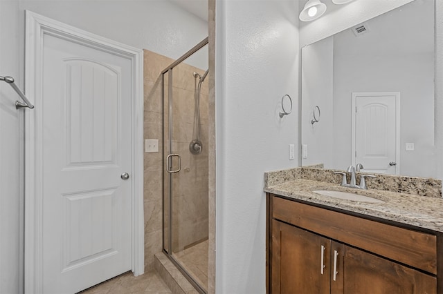 bathroom featuring vanity and a shower with door