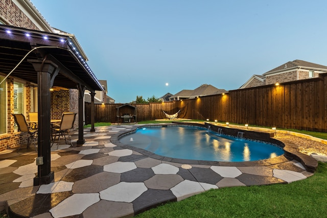 pool at dusk with a patio area