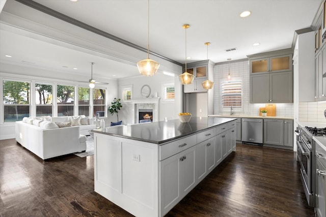 kitchen featuring appliances with stainless steel finishes, pendant lighting, a center island, gray cabinets, and ornamental molding