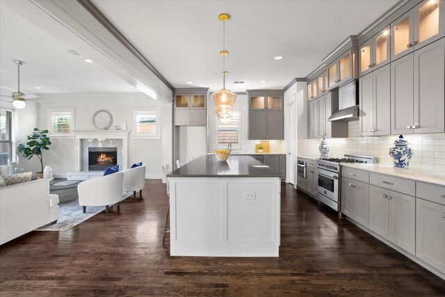 kitchen with pendant lighting, backsplash, a large island with sink, and a breakfast bar area