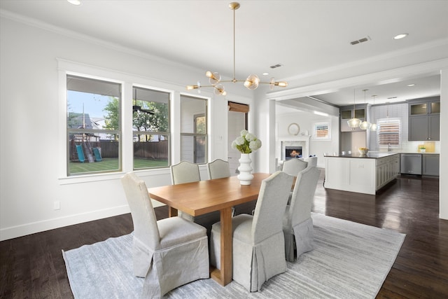 dining space with ornamental molding, dark hardwood / wood-style floors, and a chandelier