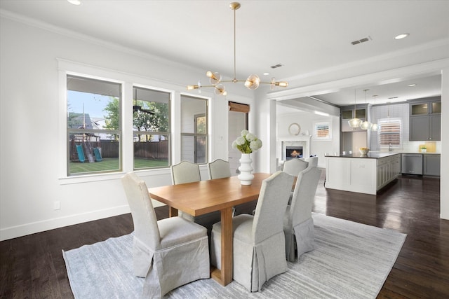 dining space featuring crown molding, dark hardwood / wood-style floors, and an inviting chandelier