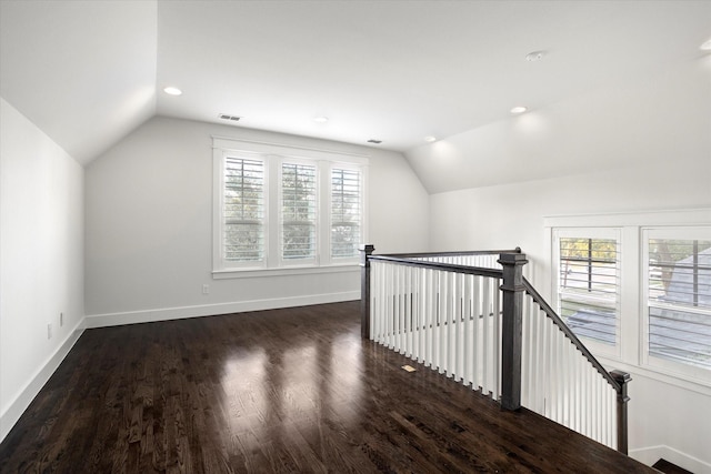 additional living space with dark hardwood / wood-style flooring and vaulted ceiling