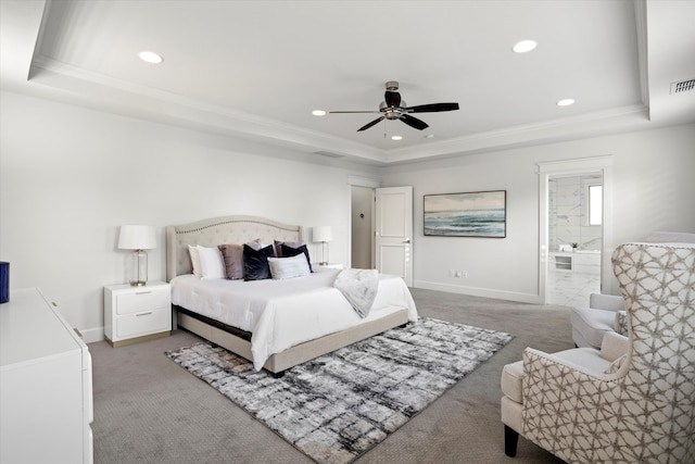 carpeted bedroom with connected bathroom, a tray ceiling, ceiling fan, and crown molding