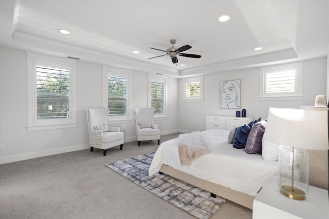 carpeted bedroom featuring a tray ceiling, crown molding, and ceiling fan