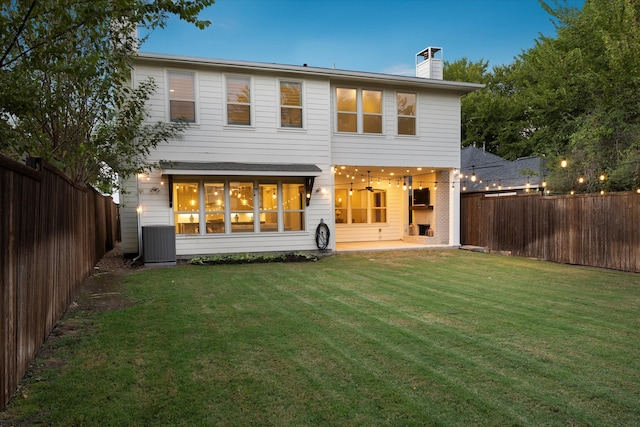 back of house with cooling unit, a patio area, and a yard