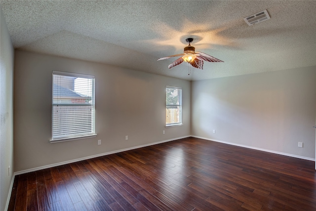 empty room with ceiling fan, a textured ceiling, and dark hardwood / wood-style flooring