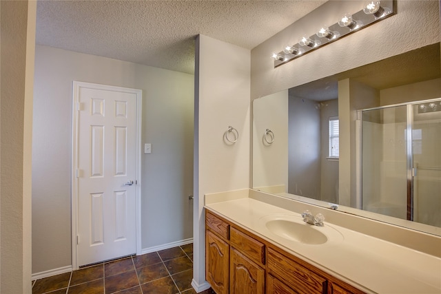 bathroom with vanity, tile patterned flooring, a textured ceiling, and an enclosed shower