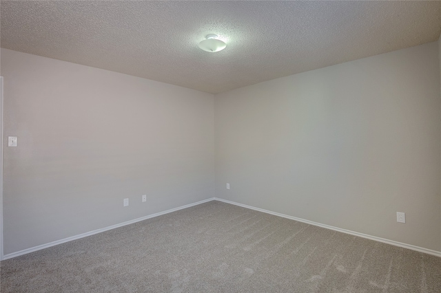 unfurnished room with a textured ceiling and carpet flooring