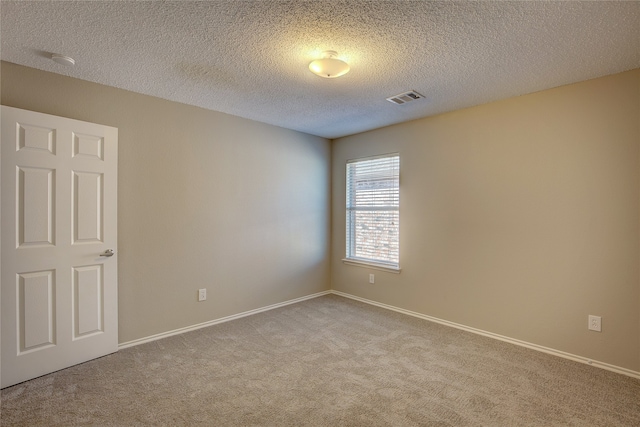 carpeted spare room featuring a textured ceiling