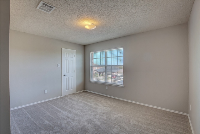 carpeted empty room with a textured ceiling