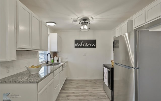 kitchen featuring stainless steel appliances, white cabinets, light hardwood / wood-style floors, and sink