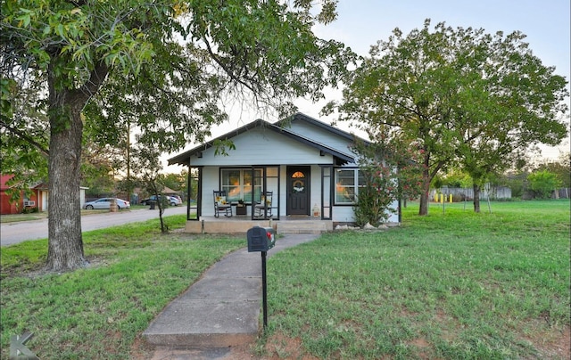 bungalow-style house with covered porch and a front yard