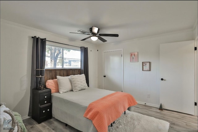 bedroom featuring crown molding, light hardwood / wood-style floors, and ceiling fan