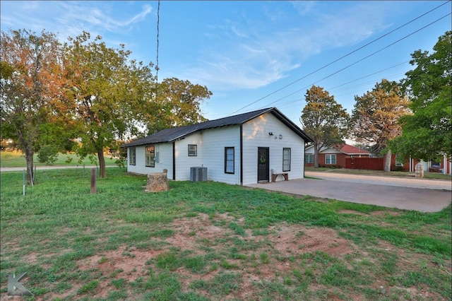 exterior space featuring central AC unit and a front yard