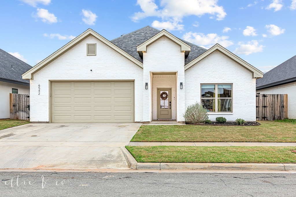 view of front of property with a front yard and a garage