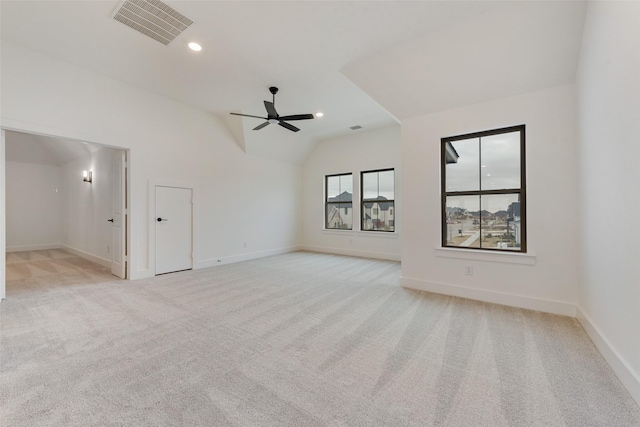 carpeted empty room with vaulted ceiling and ceiling fan