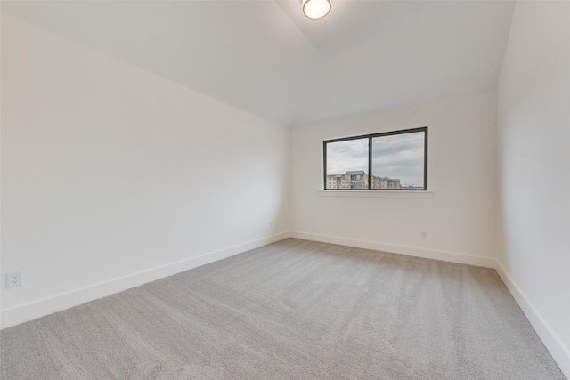 unfurnished room featuring carpet floors and vaulted ceiling