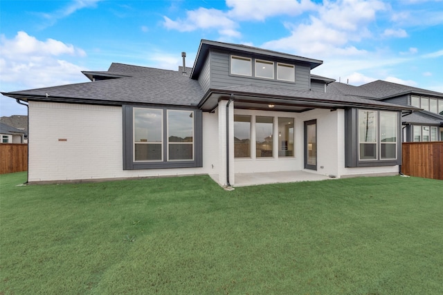 rear view of house featuring a patio area and a yard