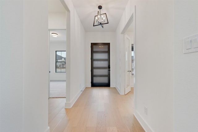 foyer with light hardwood / wood-style floors and a notable chandelier