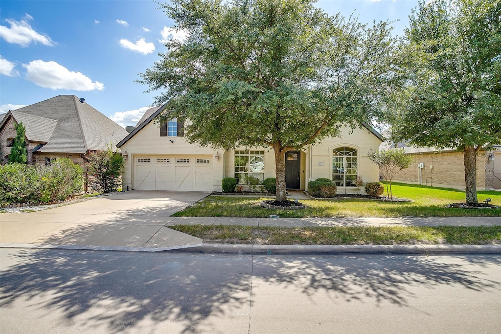 view of front of property with a garage and a front lawn