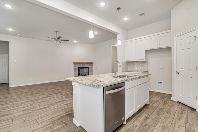 kitchen with white cabinetry, dishwasher, hanging light fixtures, and light stone counters