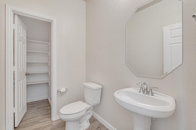 bathroom with hardwood / wood-style floors and toilet