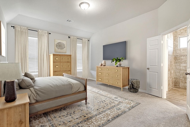 carpeted bedroom featuring connected bathroom and multiple windows