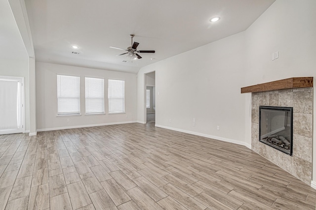 unfurnished living room featuring ceiling fan and a fireplace