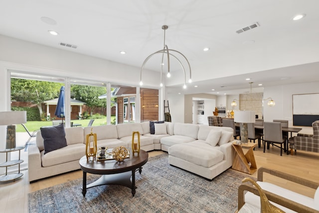 living room featuring an inviting chandelier, hardwood / wood-style floors, and a wealth of natural light