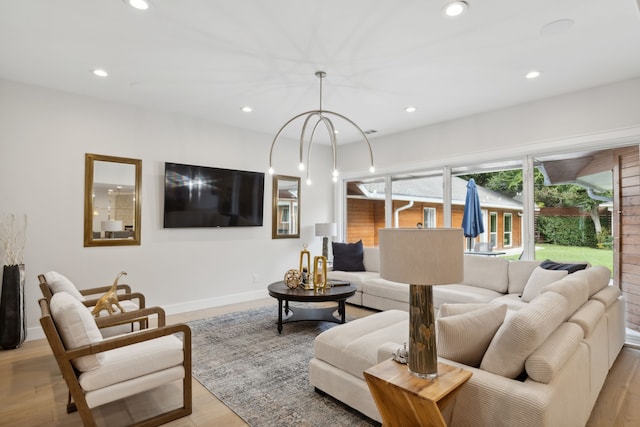 living room with a notable chandelier and light wood-type flooring