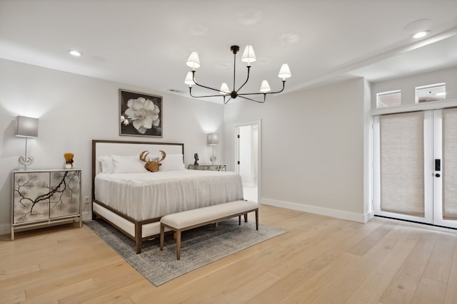 bedroom with an inviting chandelier and light hardwood / wood-style floors