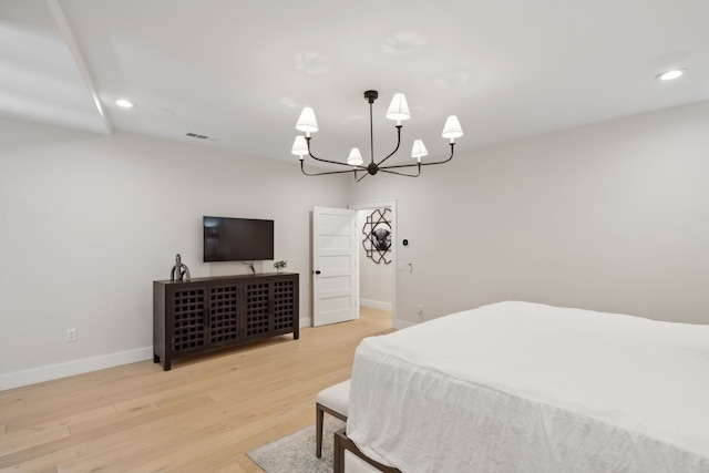 bedroom with a notable chandelier and light hardwood / wood-style floors