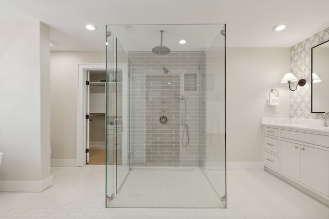 bathroom with tile patterned flooring, walk in shower, and vanity