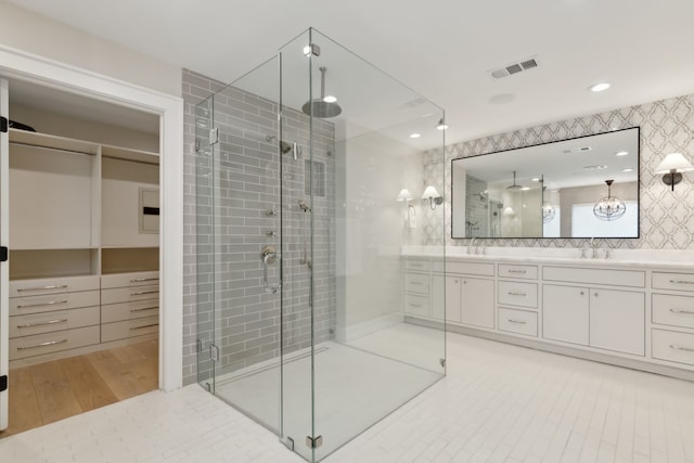 bathroom with hardwood / wood-style flooring, walk in shower, and vanity