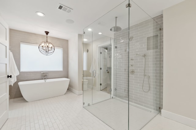 bathroom featuring plus walk in shower, tile patterned flooring, a chandelier, and toilet