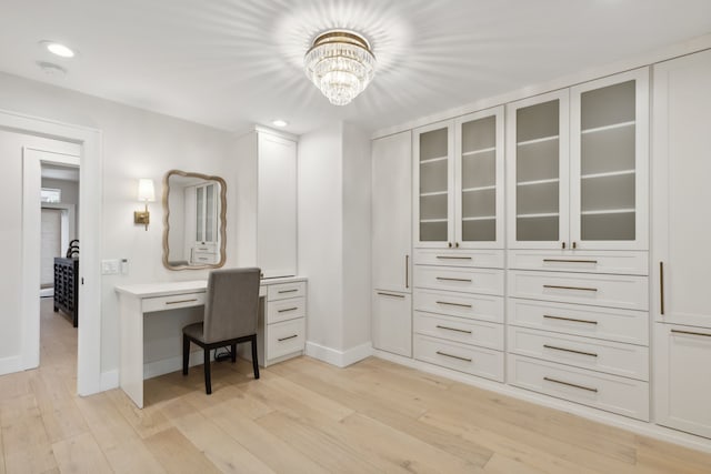 home office with light wood-type flooring and a chandelier