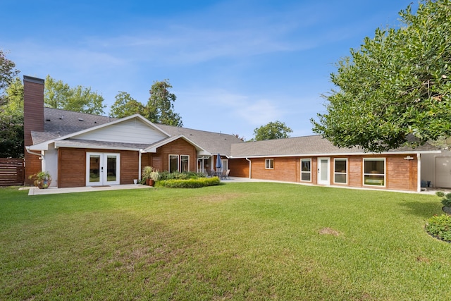 back of house featuring french doors and a yard