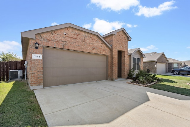 view of front of house featuring a front yard, central air condition unit, and a garage