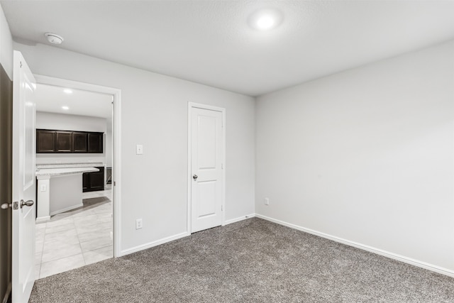 unfurnished bedroom with light colored carpet and a closet