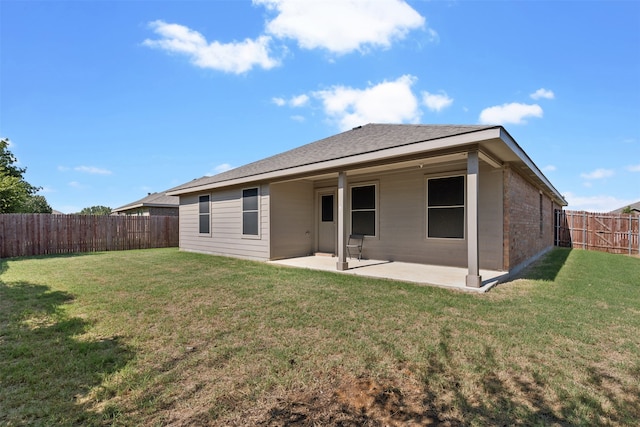 back of property with a yard and a patio area