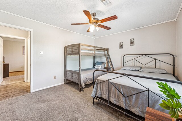 1424 Prairie Wind Blvd, Stephenville, TX 76401 - carpeted bedroom featuring crown molding, a textured ceiling, baseboards, and a ceiling fan