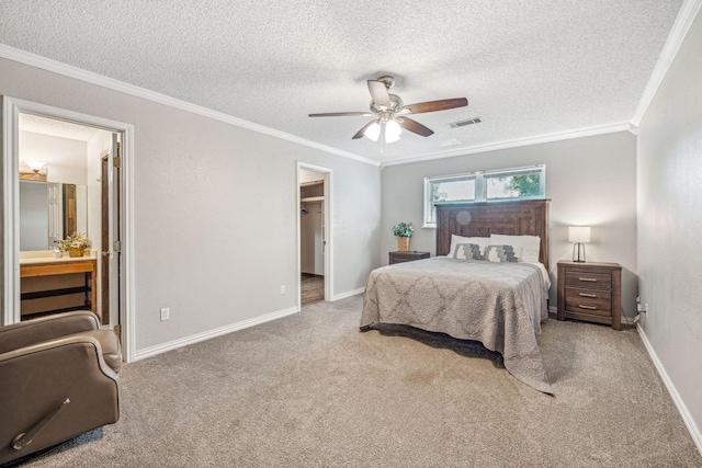 1424 Prairie Wind Blvd, Stephenville, TX 76401 - carpeted bedroom featuring ornamental molding, a textured ceiling, a walk in closet, a ceiling fan, and connected bathroom