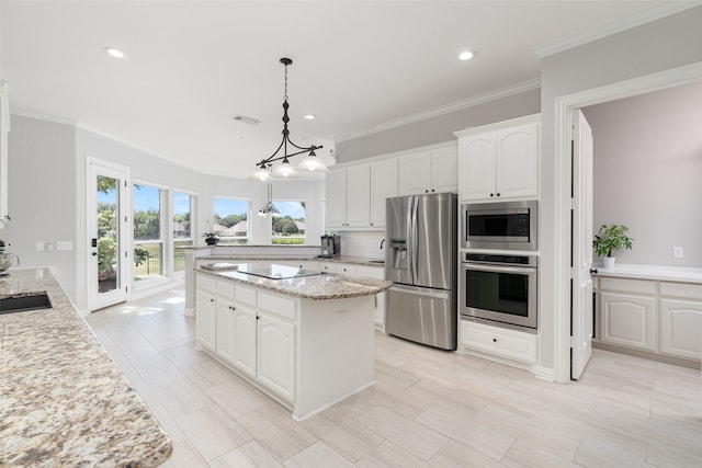 kitchen with pendant lighting, stainless steel appliances, light stone countertops, and white cabinetry