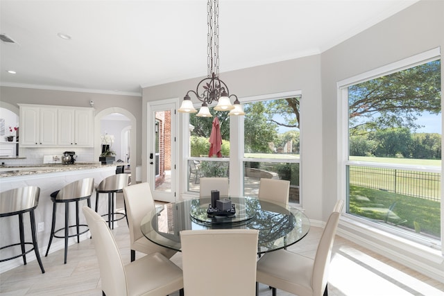 dining space featuring a notable chandelier and crown molding