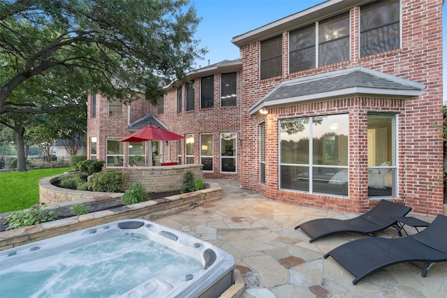 back of house with a patio and a hot tub