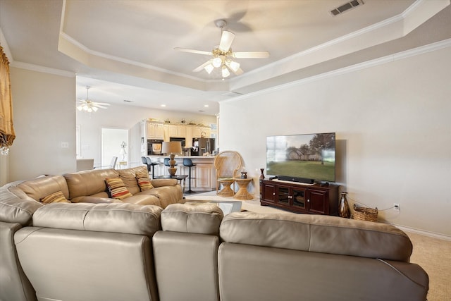 carpeted living room featuring a raised ceiling, crown molding, and ceiling fan